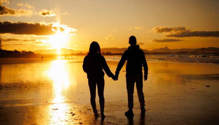a couple walking in the sunset